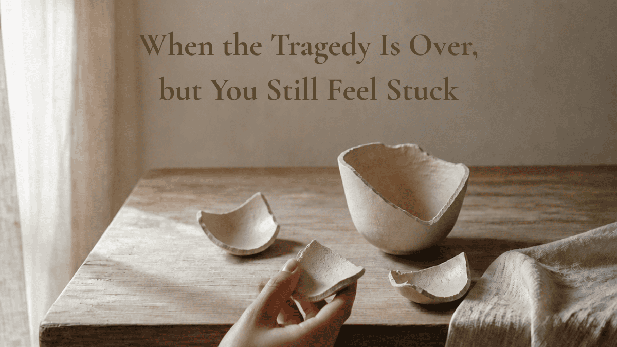 A person examining one pottery piece among several broken pieces on a table, representing healing one piece at a time.